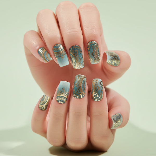 Close-up of a hand with decorative nail art on a blurred background